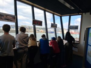 Un groupe d'enfants observe le déchargement d'un navire de commerce au Tréport , via le Port Center